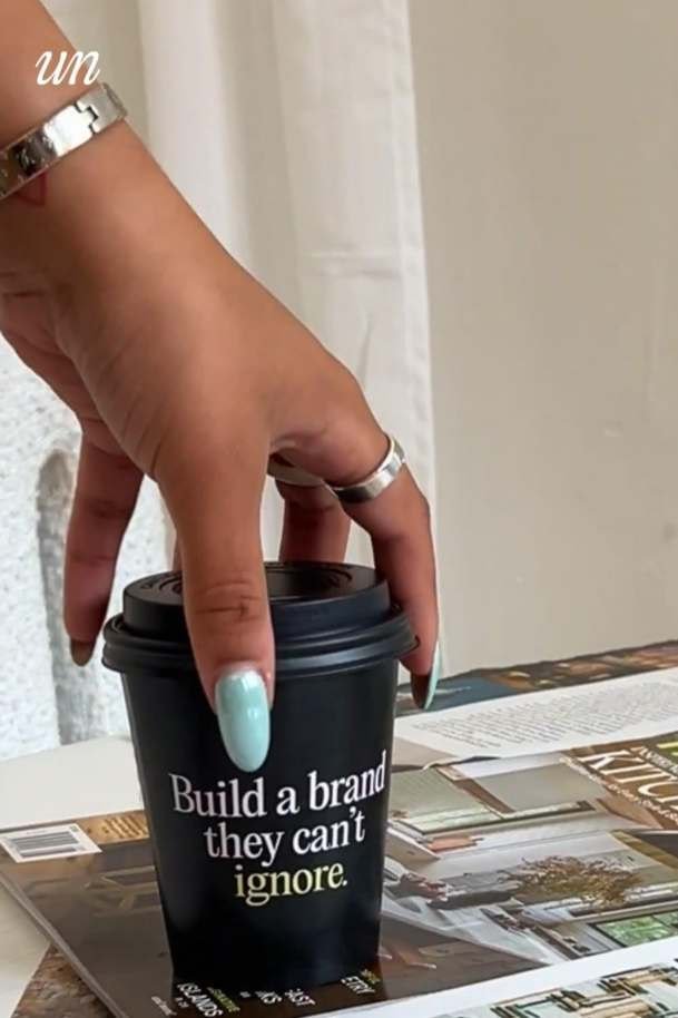 Hand holding a takeaway coffee cup