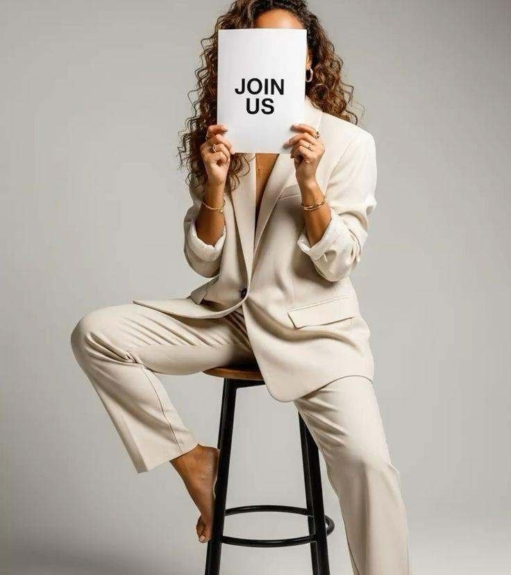 Woman in a cream suit holding a sign