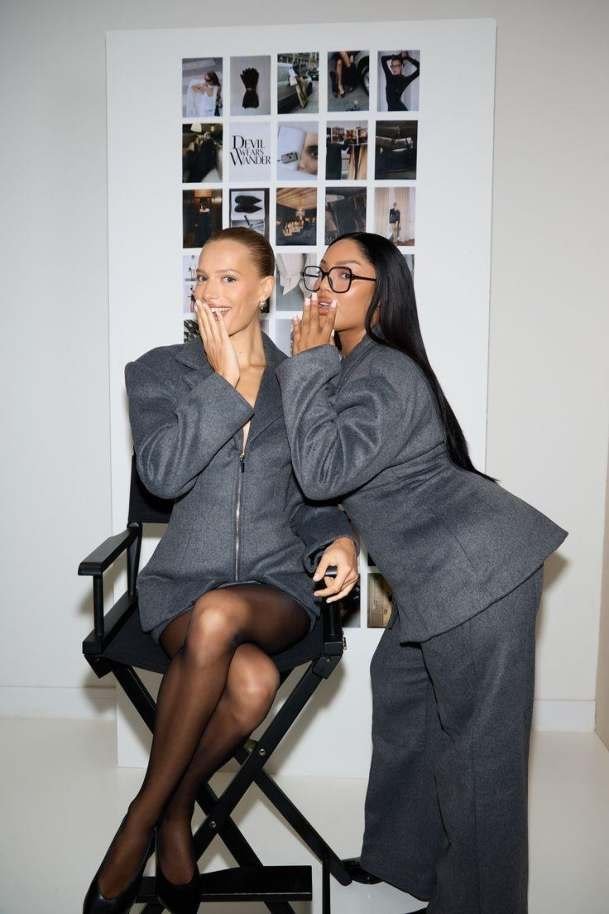 Two women in dark tailoring in an editorial studio portrait